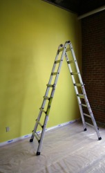 A ladder and dropcloth in a room ready to be painted. A ladder and dropcloth in a room ready to be painted.