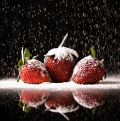 Strawberries getting a dusting of powdered sugar. Strawberries getting a dusting of powdered sugar.