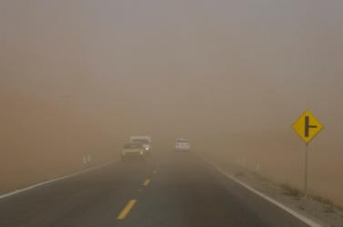 A road nearly hidden by a dust storm. A road nearly hidden by a dust storm.