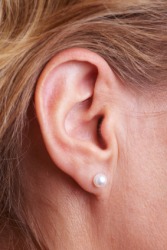 A woman with an earring on her earlobe. A woman with an earring on her earlobe.