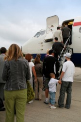 People by a plane waiting to embark. People by a plane waiting to embark.