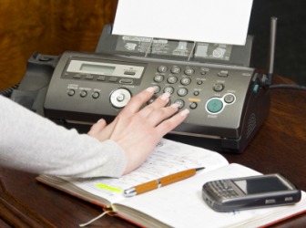 A person using a fax. A person using a fax.