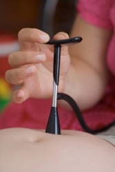 A midwife using a fetoscope. A midwife using a fetoscope.