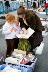A woman with her daughters at a flea market. A woman with her daughters at a flea market.