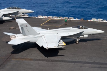 A jet sits on the flight deck of an aircraft carrier. A jet sits on the flight deck of an aircraft carrier.