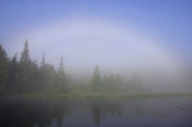 A fogbow over a lake. A fogbow over a lake.