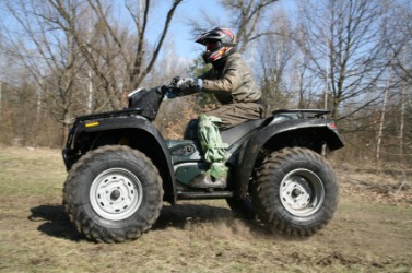 A man riding an ATV. A man riding an ATV.