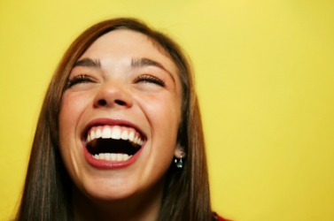 This woman is laughing at something funny. This woman is laughing at something funny.