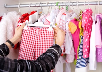 A woman choosing a garment for a child. A woman choosing a garment for a child.