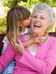 A little girl kisses her gramma. A little girl kisses her gramma.