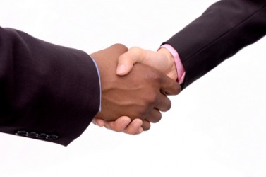 Two hands grasp in a handshake. Two hands grasp in a handshake.