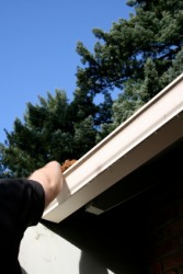 A man cleaning out the gutters on his house. A man cleaning out the gutters on his house.