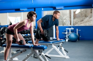 Two people working out at a gymnasium. Two people working out at a gymnasium.