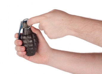 A person holding a hand grenade. A person holding a hand grenade.