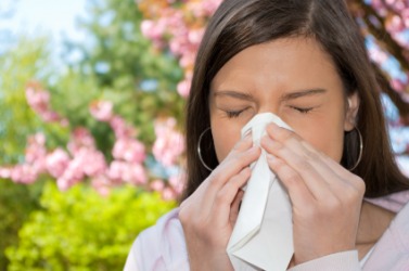 A woman wipes her nose on a handkerchief. A woman wipes her nose on a handkerchief.