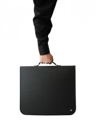 A person holds a case by its handle. A person holds a case by its handle.