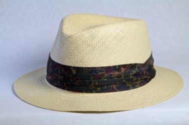 A dark hatband on a straw hat. A dark hatband on a straw hat.