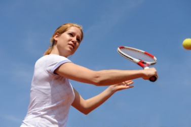 A tennis player performing a backhand volley. A tennis player performing a backhand volley.