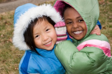 Two children with hoods on their coats. Two children with hoods on their coats.