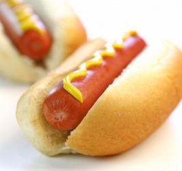 A hot dog with mustard. A hot dog with mustard.