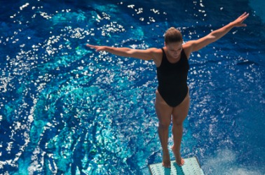 A diver about to immerse herself in water. A diver about to immerse herself in water.