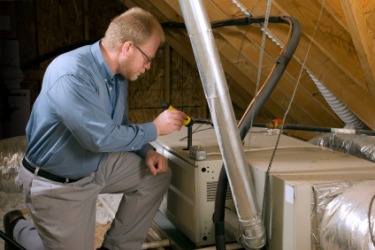 A service man performs an inspection of a furnace. A service man performs an inspection of a furnace.