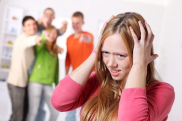 A group of people appear to be insulting this girl. A group of people appear to be insulting this girl.