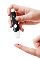 A diabetic jabs her finger to check her blood sugar. A diabetic jabs her finger to check her blood sugar.