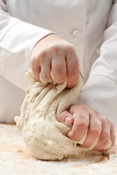 A baker kneading dough. A baker kneading dough.