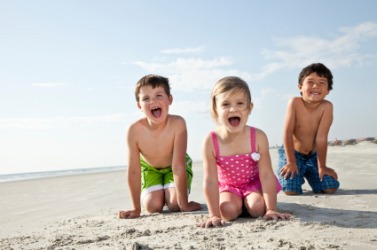 Children kneeling on the beach. Children kneeling on the beach.