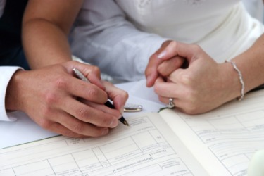 A couple signs a wedding register. A couple signs a wedding register.