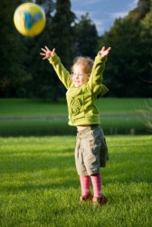A little girl throws a ball. A little girl throws a ball.