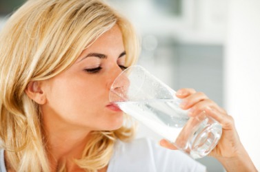 A woman swallows a glass of water. A woman swallows a glass of water.