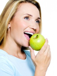 A woman takes a bite out of an apple. A woman takes a bite out of an apple.