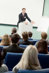 A man gives a lecture at a business conference. A man gives a lecture at a business conference.