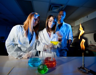 College students performing an experiment in a laboratory. College students performing an experiment in a laboratory.