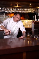 A bartender pouring a drink. A bartender pouring a drink.
