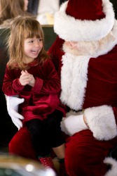 A little girl sits on Santa's lap. A little girl sits on Santa's lap.