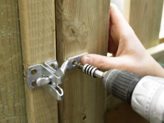 A latch being installed to a gate. A latch being installed to a gate.
