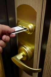 A man uses a magnetic card to open a hotel room door. A man uses a magnetic card to open a hotel room door.