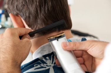 A barber trims the hair at the nape of this mans neck. A barber trims the hair at the nape of this mans neck.