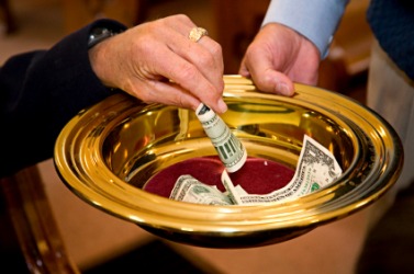 A person making an offering in church. A person making an offering in church.