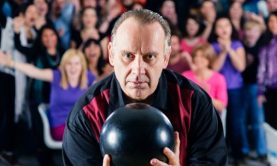 A bowler plays in front of a group of onlookers. A bowler plays in front of a group of onlookers.