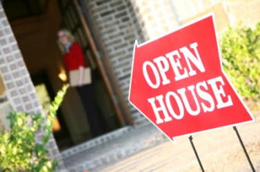 A realtor waits at the door of an open house. A realtor waits at the door of an open house.