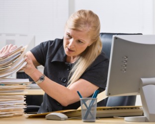 This woman seems overwhelmed with paperwork. This woman seems overwhelmed with paperwork.