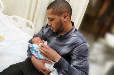 A new parent holds his child. A new parent holds his child.