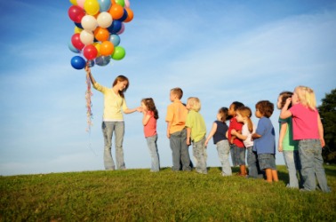 Children displaying a great deal of patience as they wait for a balloon. Children displaying a great deal of patience as they wait for a balloon.
