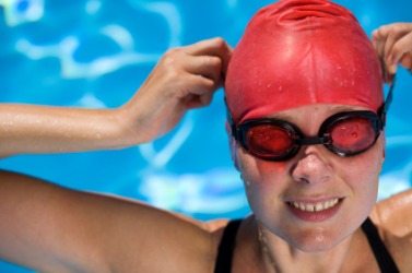 A swimmer putting on a bathing cap. A swimmer putting on a bathing cap.