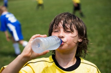 A boy quenches his thirst on a warm day. A boy quenches his thirst on a warm day.