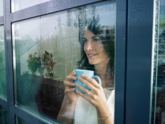 A woman looks out at the rainy day. A woman looks out at the rainy day.